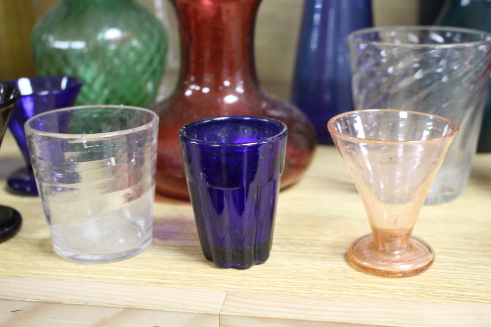 A collection of assorted coloured glassware including hyacinth vases, tallest 21cm